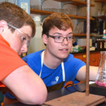 George, who was born with a leg-length discrepancy, with a fellow student in the chemistry lab