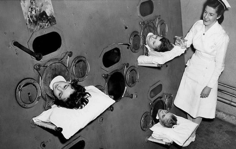 Polio patients breathe with the help of an iron lung.