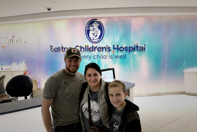 Nicholas, who had a double-switch procedure for CCTGA, poses with his parents in the lobby of Boston Children's.