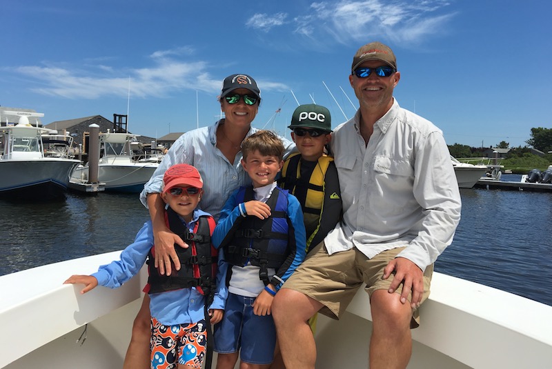 Julie and her family pose on a boat