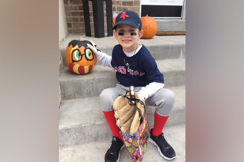 little boy with midaortic syndrome wearing a baseball uniform