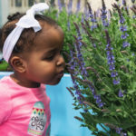 little girl with cdh smells flowers