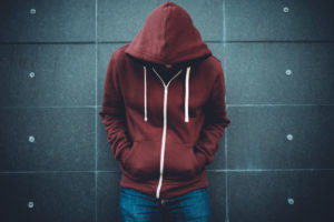 Depressed teen boy leans against wall