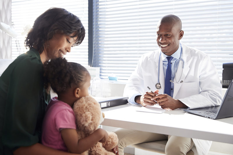 Parent and child consulting with surgeon in office