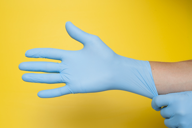 nurse putting on gloves to perform urodynamics testing