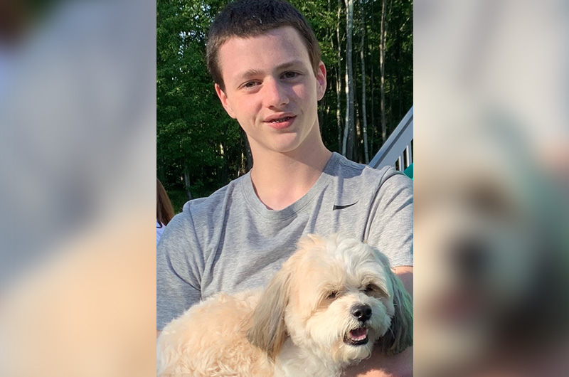 Ryan, who had spinal fusion surgery for scoliosis, holds his dog Leo..
