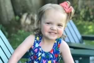 Stella, who had treatment for neuroblastoma, smiles outside