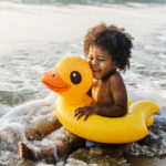 Toddler in duck tube on beach