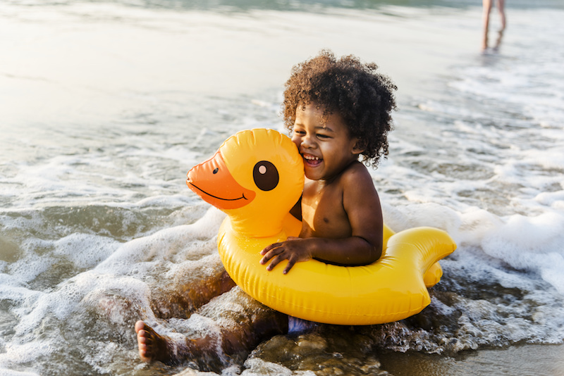 Toddler in duck tube on beach