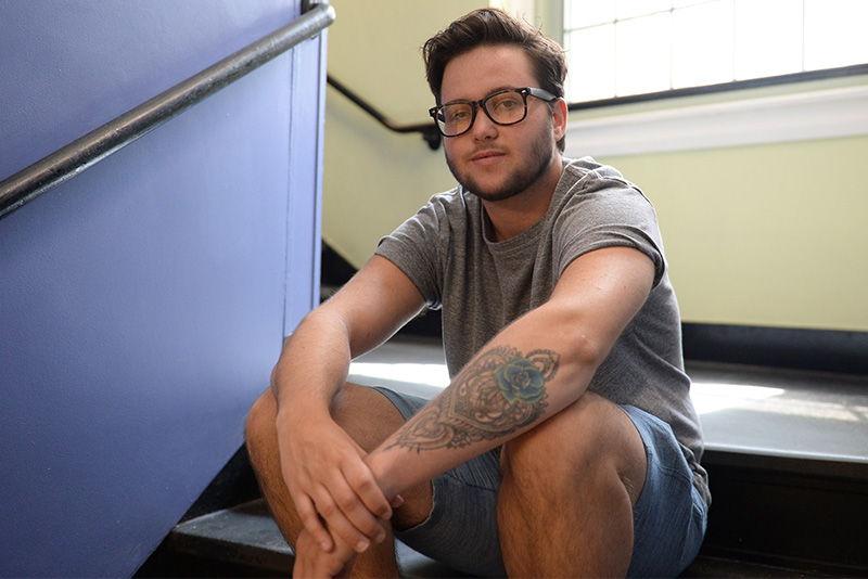 nick sits in a stairwell after coming out as trans