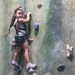 Grace, who had surgery for a cavernous malformation, climbs a rock wall