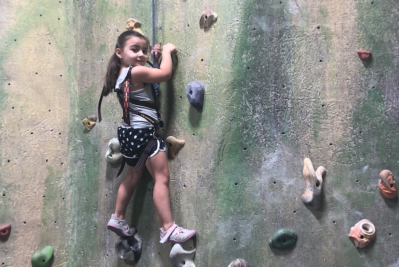 Grace, who had surgery for a cavernous malformation, climbs a rock wall