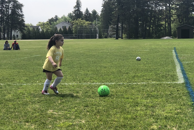 Grace, who had surgery for a cavernous malformation, runs on the soccer field. 