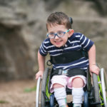 boy with spina bifida racing in his wheelchair