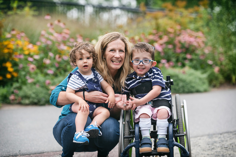 boy with spina bifida poses with his mom and brother