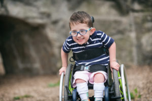 boy with spina bifida racing in his wheelchair