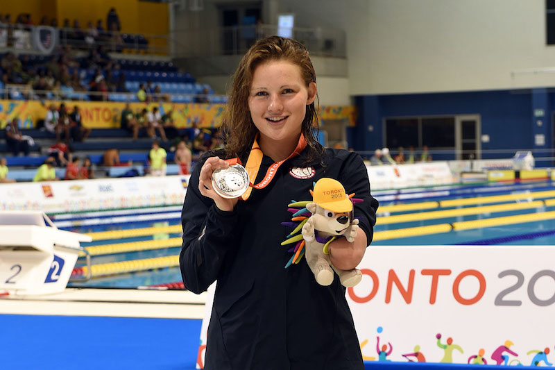 Anna Johannes displays her silver medal next to the pool at the 2015 Pan Am Games in Toronto.
