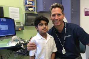 Saif and his physician pose together after the surgery that corrected his cervical spine.