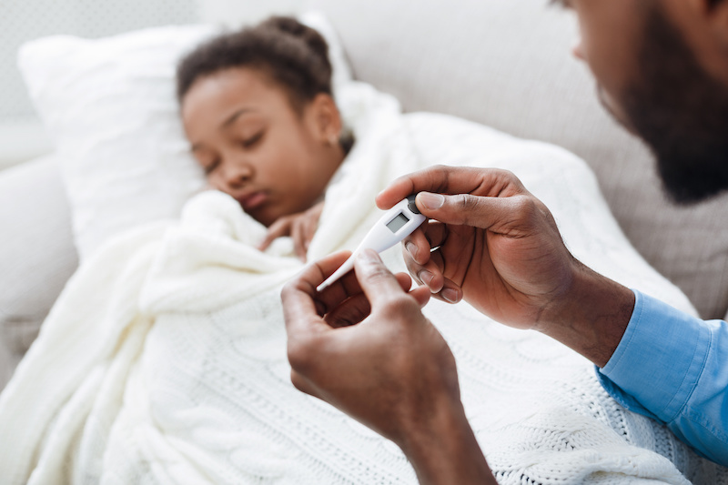 Dad caring for girl with flu takes her temperature