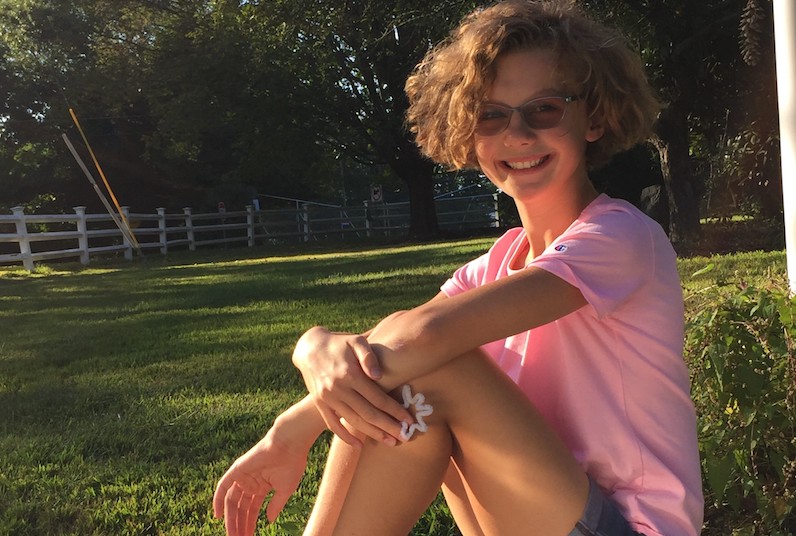 Lia, who had surgery for kidney cancer, poses on a lawn