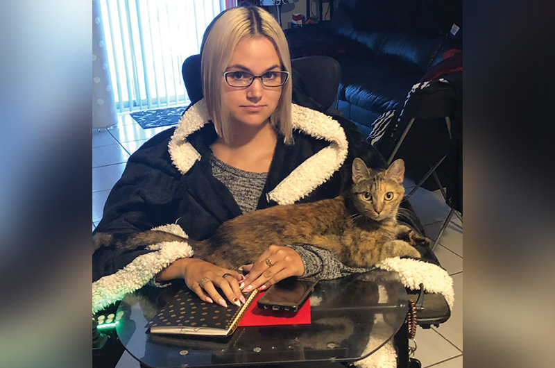 sydney sits with her cat on her lap
