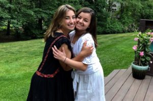 Gabbi, who survived cancer, gives her cousin a hug on her outside deck