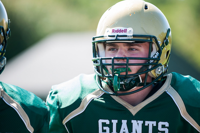 Chase, who has brachial plexus birth palsy, in his uniform and helmet during a football game.