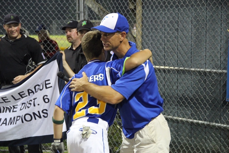 Nate gets a hug from his dad at a game.