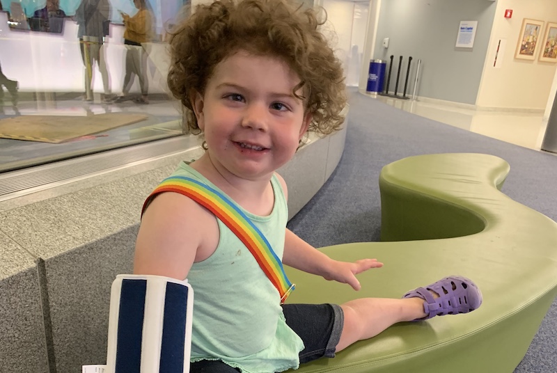 Ellery, who has opsoclonus myoclonus syndrome, in the lobby of Boston Children's. 