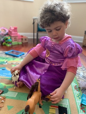 Ellery, who has opsoclonus myoclonus syndrome, plays with her horse figurines. 