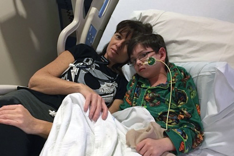 Manda and Chase Gotshall, who has SDS, lie in his bed in the hospital.