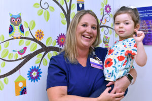 Amelia, who had surgery for epilepsy, is held by her EEG tech