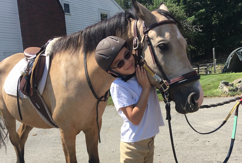 Luca, who participates in the Cardiac Neurodevelopmental Program, with the horse from his camp
