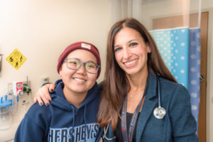 Kaitlyn, who had osteosarcoma, poses with her oncologist