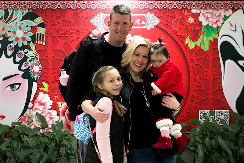 Shannon holds Everli in a family photo at an airport in China.