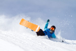 Snowboarder takes a fall - luckily they are wearing a helmet.