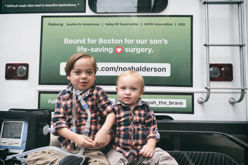 Noah, who had a biventricular repair, sits on the back of an RV with his brother