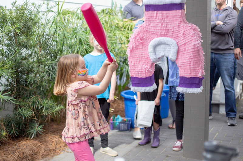 Emma, who had hip dysplasia, swings a bat at a pinata shaped like the spica cast she had to wear for 10 weeks.