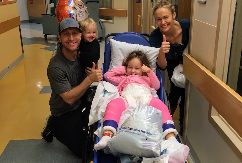 Emma and her family give a thumbs up after her hip dysplasia surgery. 