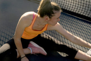 Female athlete stretches outside