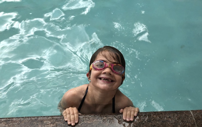 Jane, who had acute flaccid myelitis, having fun at a pool. 