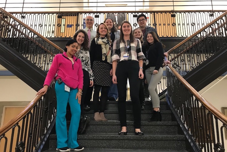 Kristen, who had surgery for epilepsy, poses on the stairs of the hospital with her colleagues.