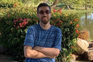 Jason, who had surgery for seizures, poses outside in a park