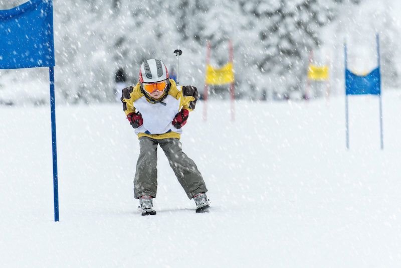 Young ski racer during a slalom competition. Ski and snowboard injury prevention will keep this skier moving through the gates.