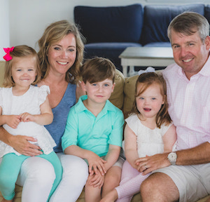 Family poses with all three children on their parents' laps