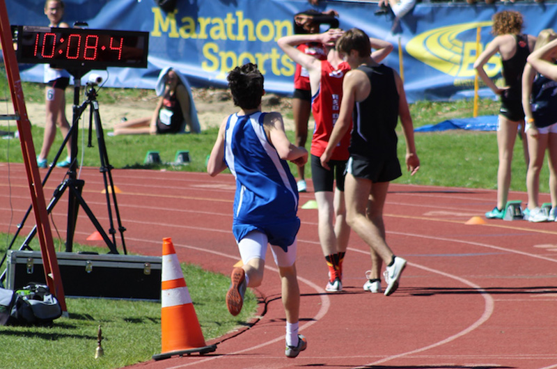 Will, who had an avulsion fracture, runs toward the finish line at an outdoor track meet.