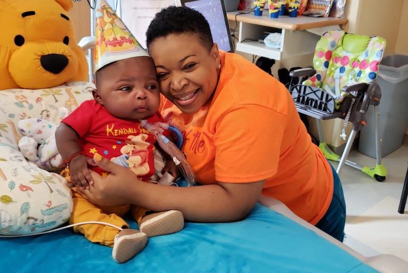 Kenny, a preemie in the ICU, is held by his mom on his first birthday