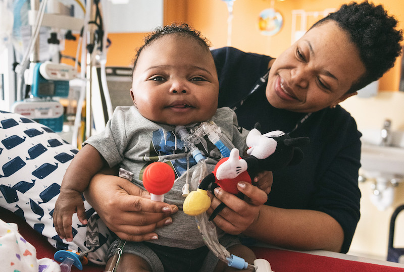 Kenny, who was born prematurely, plays with his mom in his hospital bed