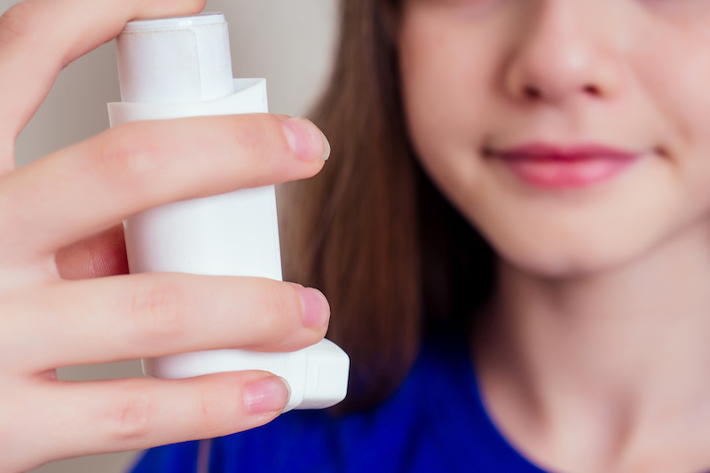 girl holding an inhaler for asthma