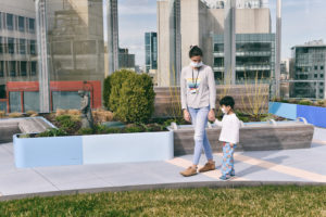Mother and child hold hands on Boston Children's roofdeck